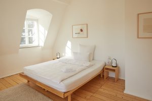 Schlafzimmer mit Doppelbett, zwei Nachttischen, Wasser, Handtuchset