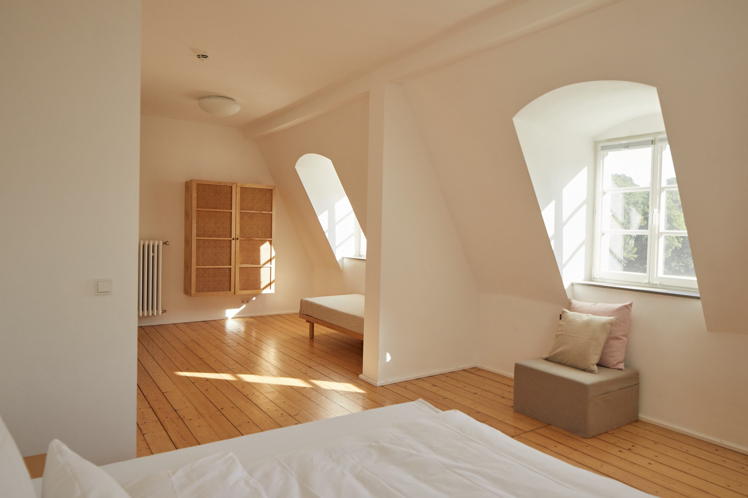 Schlafzimmer mit Doppelbett und Sessel, Daybed, Schrank, Dielenfußboden