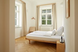 Schlafzimmer mit Doppelbett und Sessel, Fischgrät-Parkett, Eichen-Parkett